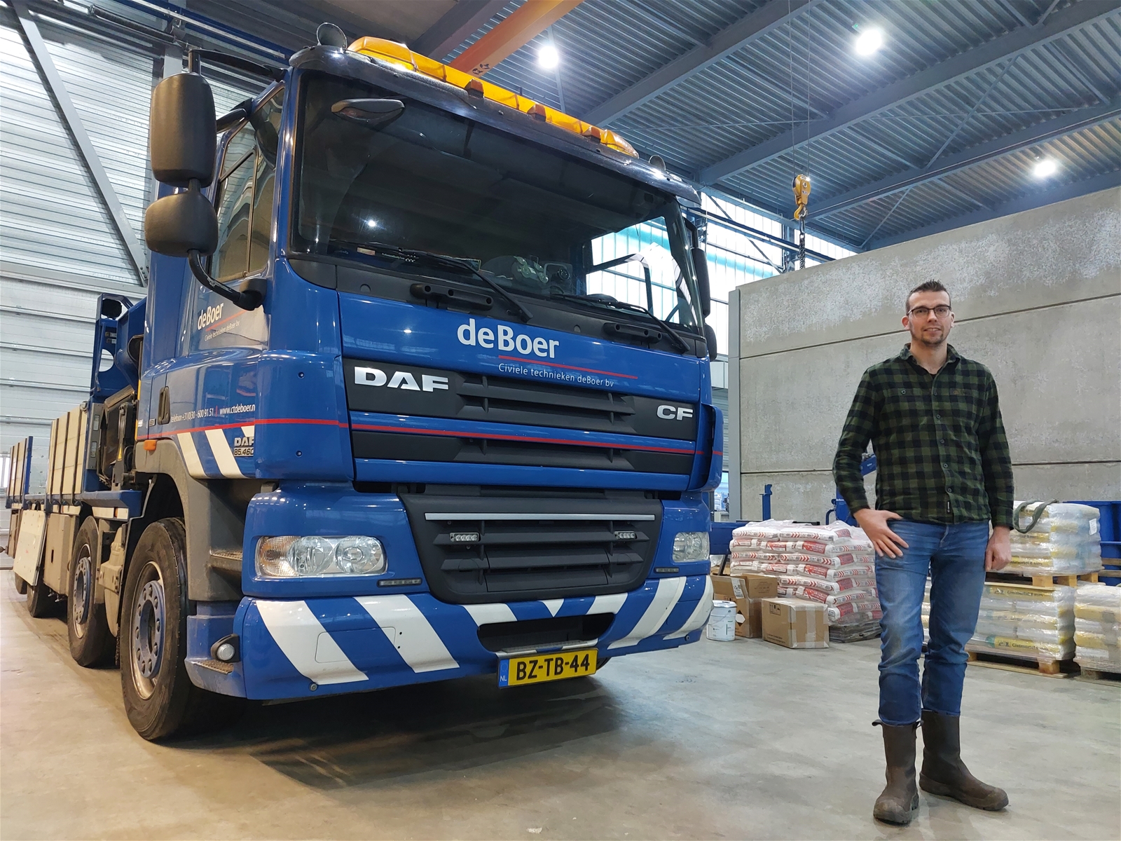 Roy Grieving poseert in de productiehal van staalconstructiebedrijf Rijnstaal voor een vrachtwagen van CT deBoer.